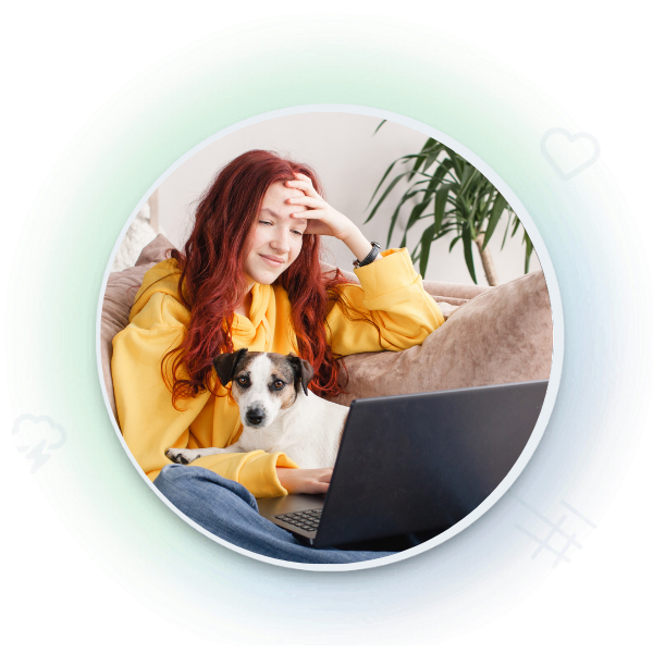girl and her dog sit on a couch looking at a laptop